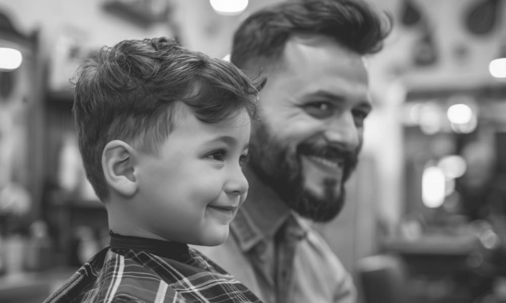 Smiling young boy with thick hair showing off a fresh haircut at the barbershop—one of the best haircuts for kids with thick hair.