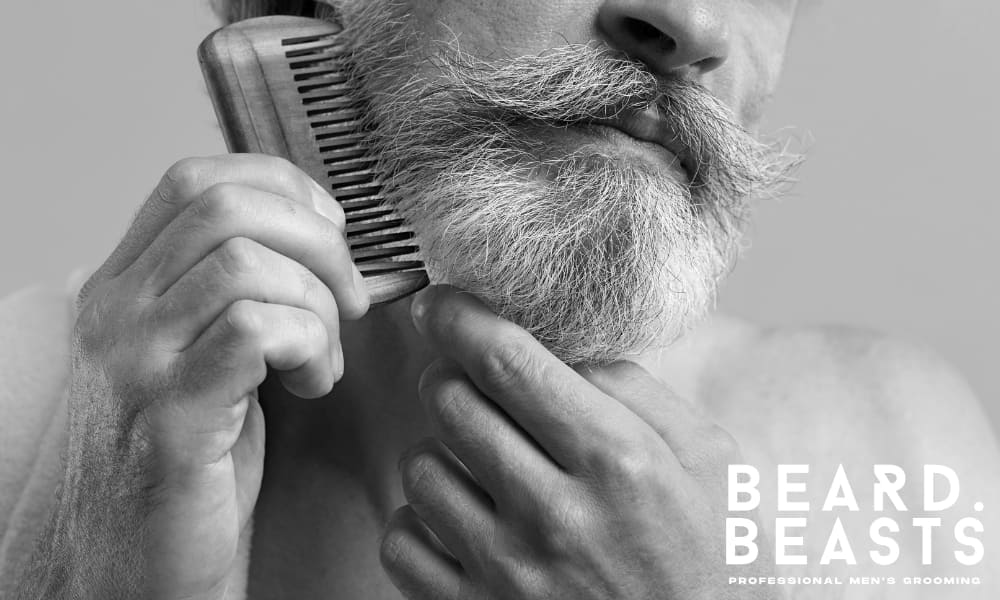 Man combing beard to train it and get his beard to lay flat during daily grooming