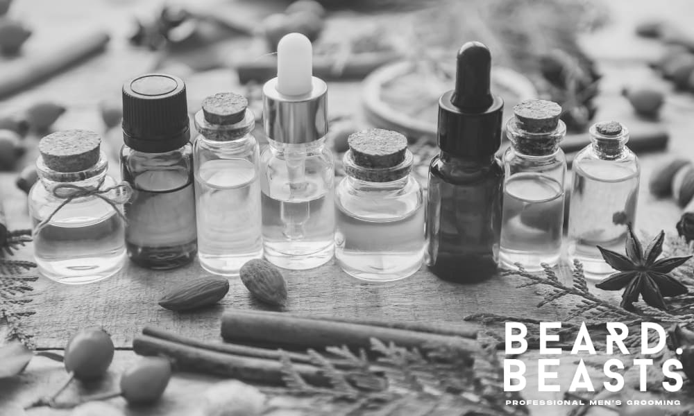 Various glass bottles of natural oils surrounded by herbs, nuts, and spices—ideal ingredients for high-quality curly beard grooming products.