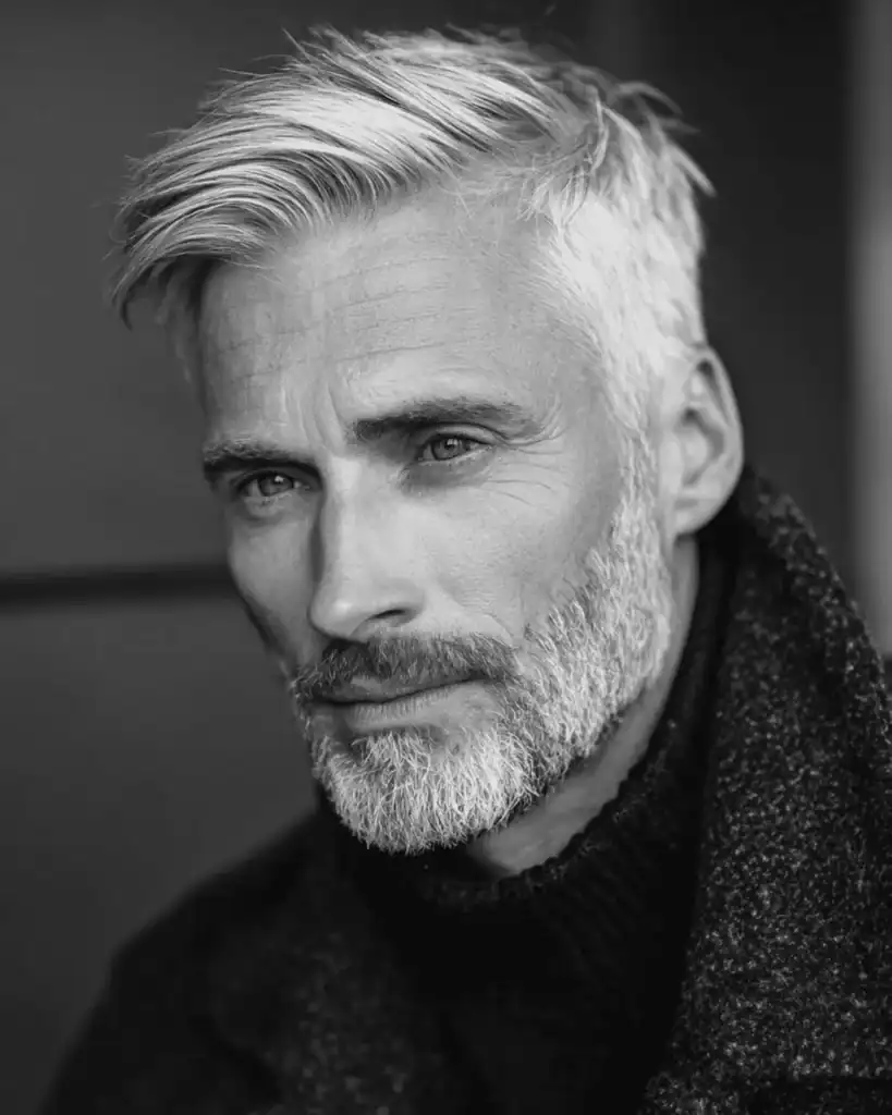 A portrait of a distinguished older man with a short boxed beard, featuring neatly trimmed cheek lines and a defined shape that enhances the jawline.