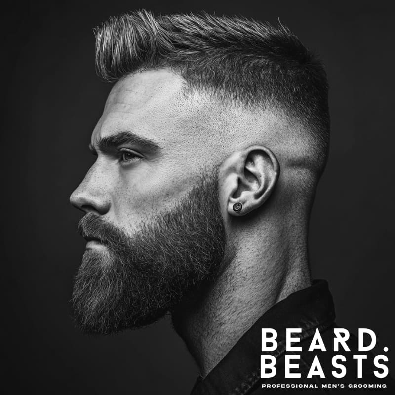 Black and white profile image of a man with a short quiff and full beard, showcasing one of the best short haircuts for men with beards.