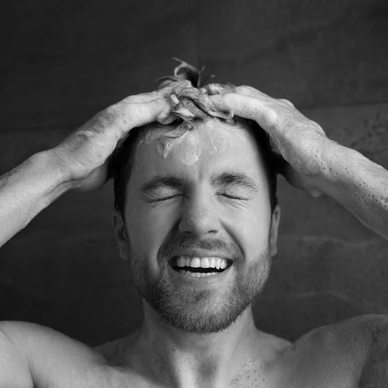 Man washing hair with shampoo before styling it messy