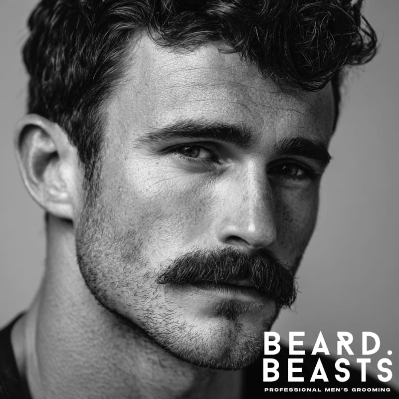 Man with a beardstache—full mustache and short stubble on the cheeks and jawline, a bold beard style for patchy cheeks that adds contrast and control.