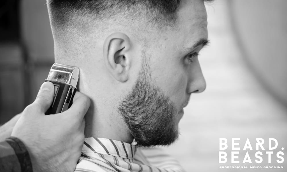 Barber shaping the neckline with clippers during a haircut