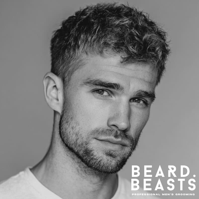 Man with a short boxed beard and faded cheeks—defined jawline and light cheek taper, a clean and structured beard style for patchy cheeks.