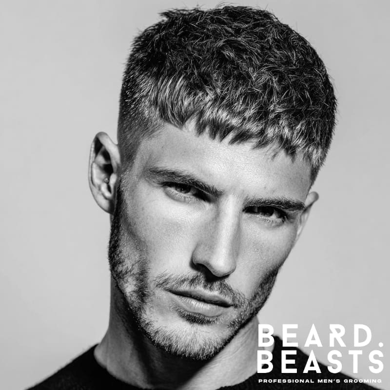 Black and white portrait of a man with a classic short textured fringe hairstyle, showcasing a timeless and versatile look for short hair.