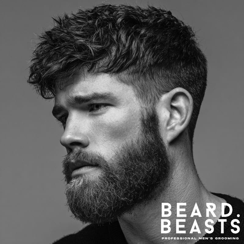 Professional young male model with a classic wavy textured crop, featuring soft, natural waves on top and short sides. The hair is styled with light, tousled waves that add subtle texture and volume, while the sides are kept neat and faded for a smooth transition. The overall look is refined, clean, and modern, offering a low-maintenance yet polished style.