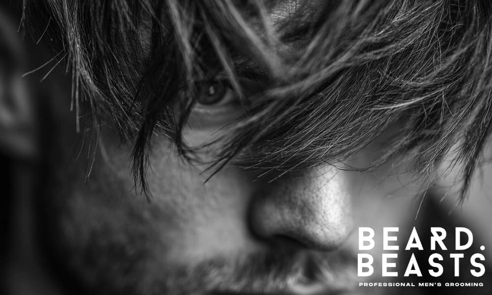 A close-up shot of a man with a hairstyle that features layered hair, highlighting its natural flow and movement.