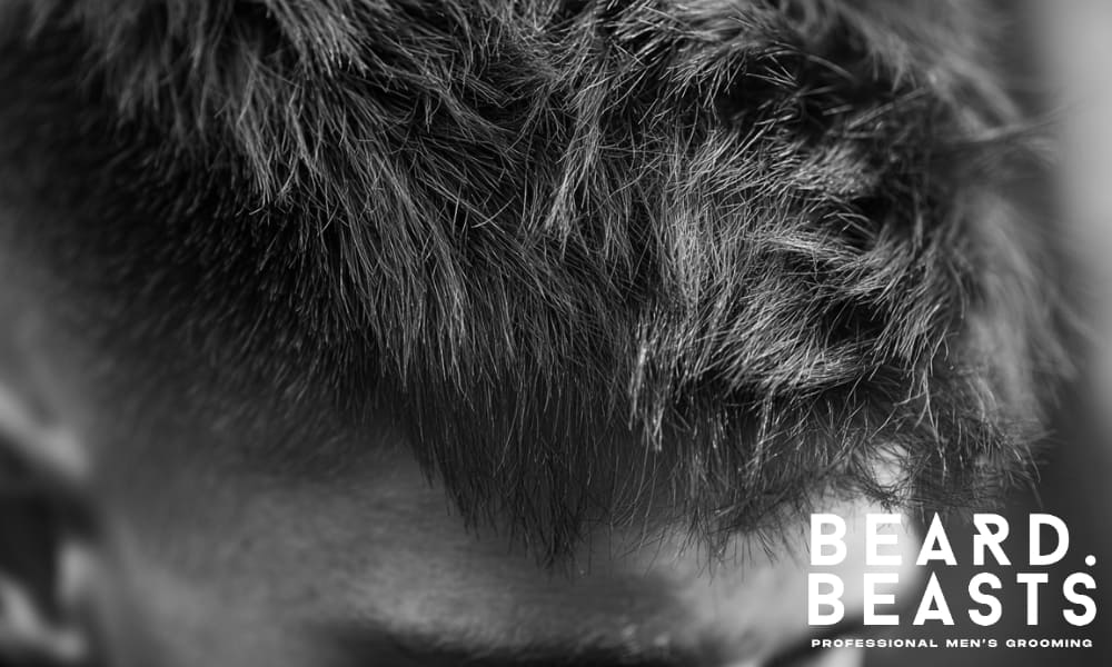 Close-up of a man's haircut, showing the texture on top and fade on the sides.