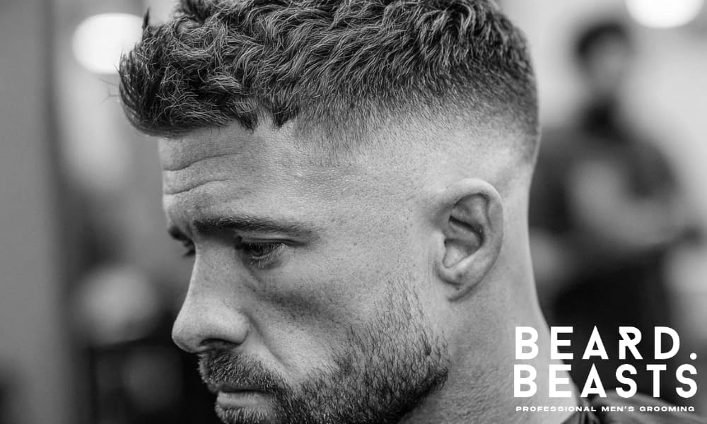 Close-up of a man styling his hair, focusing on the fade and texture for a sharp, polished look.