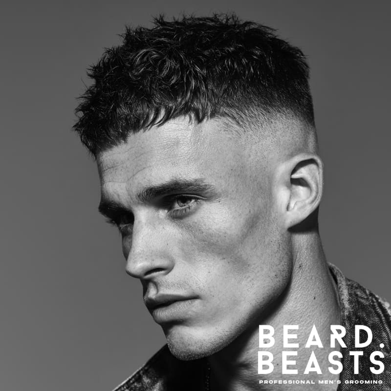 High skin fade textured crop hairstyle for men, featuring a sharp high fade on the sides with voluminous, textured curls on top for a bold, modern look.