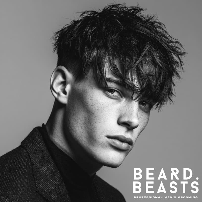 Messy long textured fringe hairstyle with voluminous layers and a clean fade, offering a bold, modern look with a natural, tousled finish.