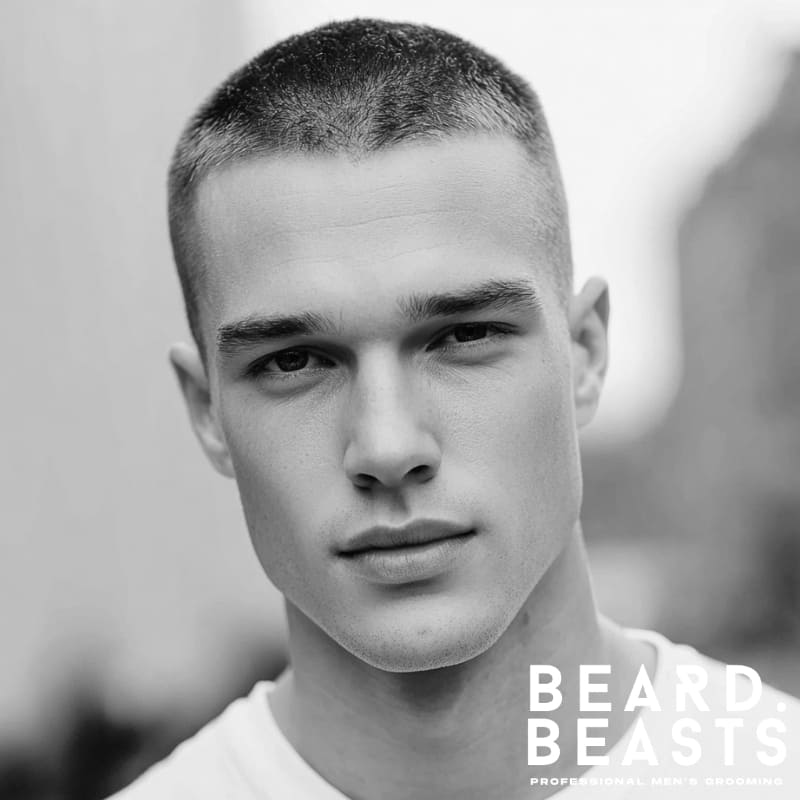 A man showcasing a traditional crew cut hairstyle with uniformly short sides (no fade) and a neatly cropped top.