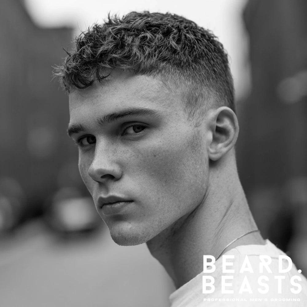 Wavy crew cut hairstyle for men featuring natural texture on top with tapered sides, ideal for a relaxed but controlled look.