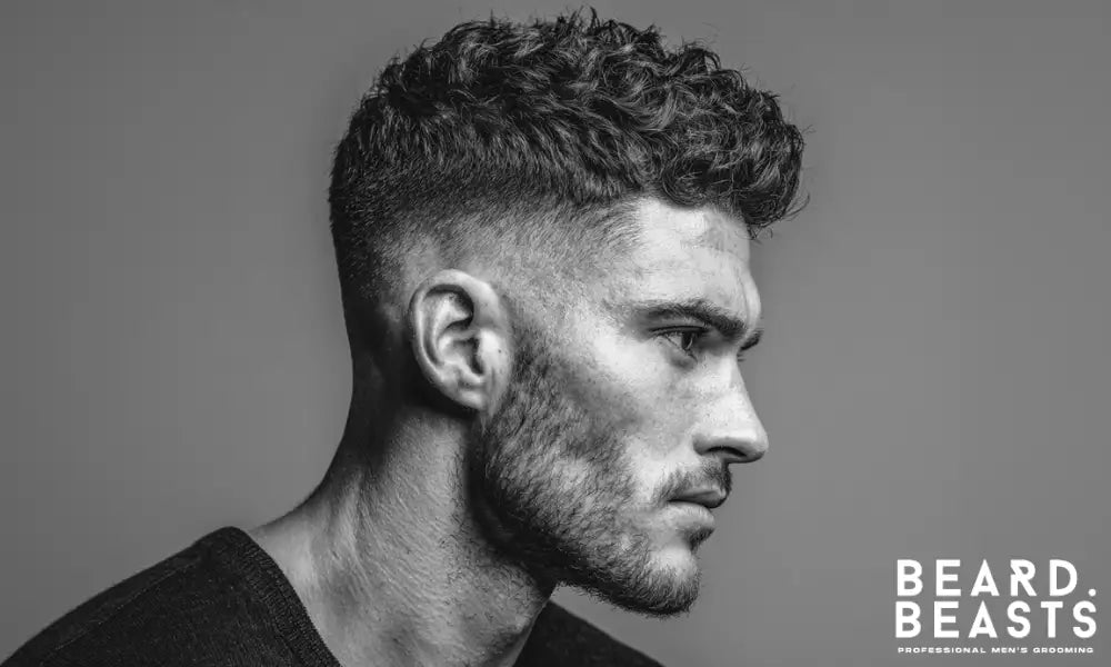 Man with a textured curly hairstyle styled using hair clay for a matte finish and natural volume.