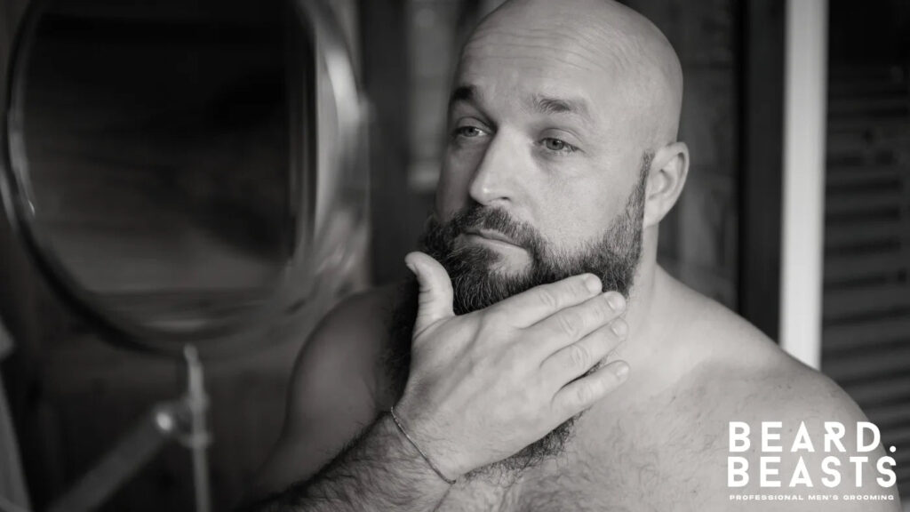 Man checking his beard in the mirror from different angles to ensure symmetry after trimming