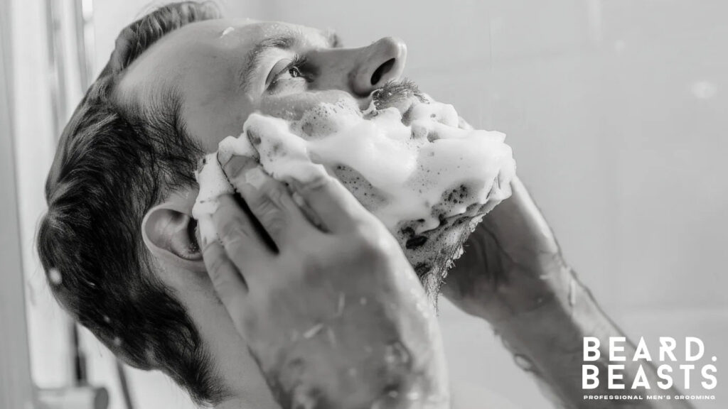 Man washing his beard with cleanser and foam in the shower, preparing for beard trimming