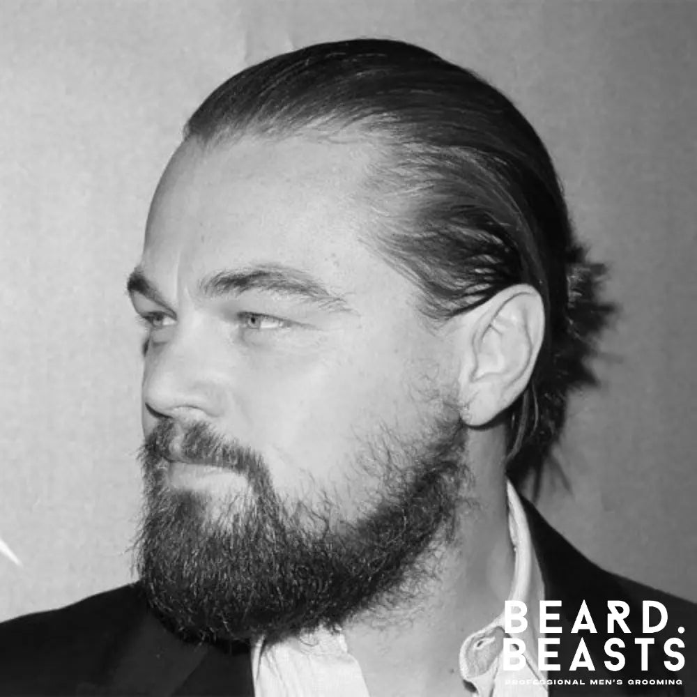 Man wearing a Hollywoodian beard with short sideburns, light upper-cheek coverage, and full growth along the jaw and chin for a defined, modern look