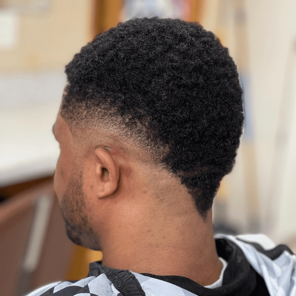 Afro Mohawk Fade with a textured top and a clean, sharp fade on the sides.