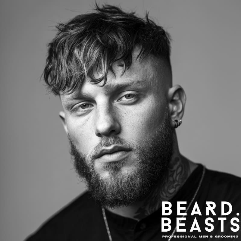 Man with a disconnected fringe haircut featuring long textured bangs and faded sides, showcasing one of the boldest fringe haircuts for men in 2025.