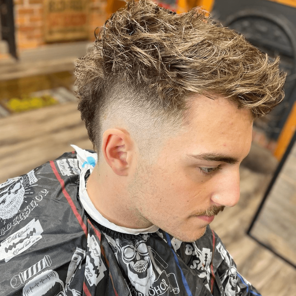 Messy Mohawk Fade with a textured, tousled top and a high skin fade on the sides.