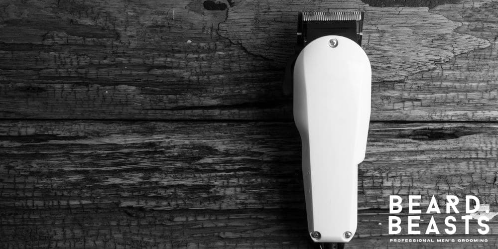 A high-quality white hair clipper resting on a rustic wooden surface. The clipper's sleek design contrasts with the natural, textured background.