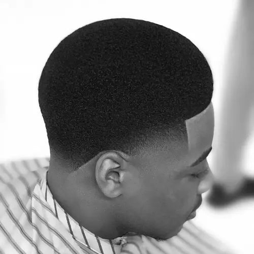 A sharp and stylish Afro taper fade haircut, featuring a clean lineup and smooth gradient fade that seamlessly blends into the skin. This precision-cut hairstyle enhances natural texture while maintaining a fresh, modern look. Perfect for those seeking a trendy and versatile fade haircut.