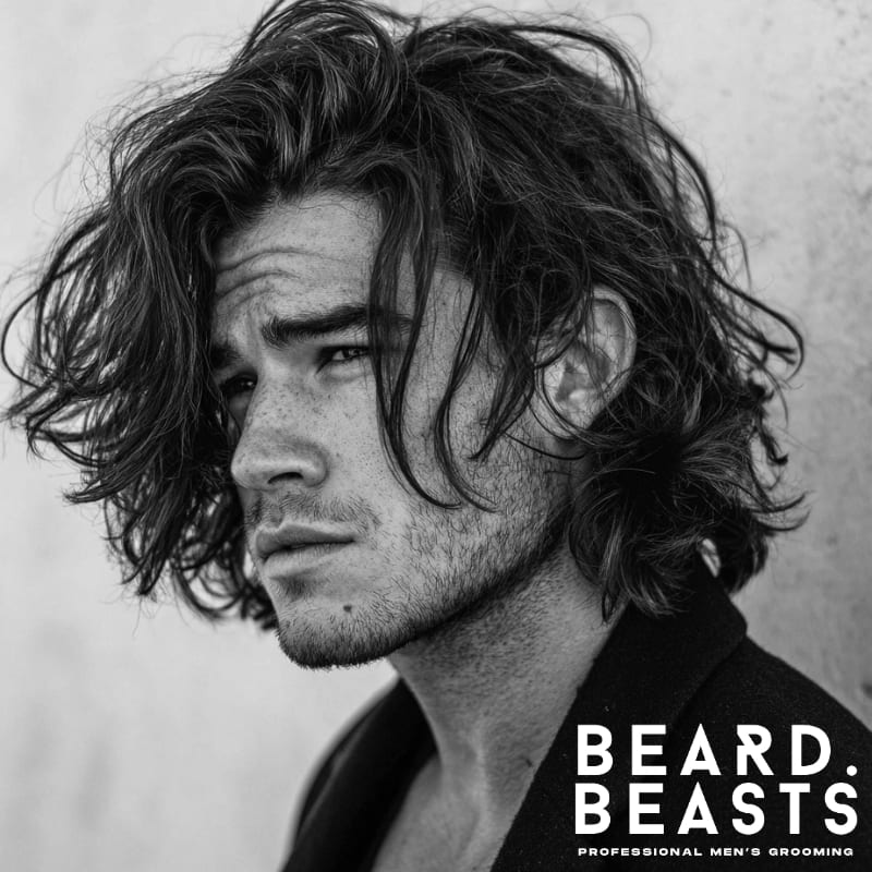 Male model with a bro flow haircut, featuring natural waves, volume, and a relaxed, tousled look.