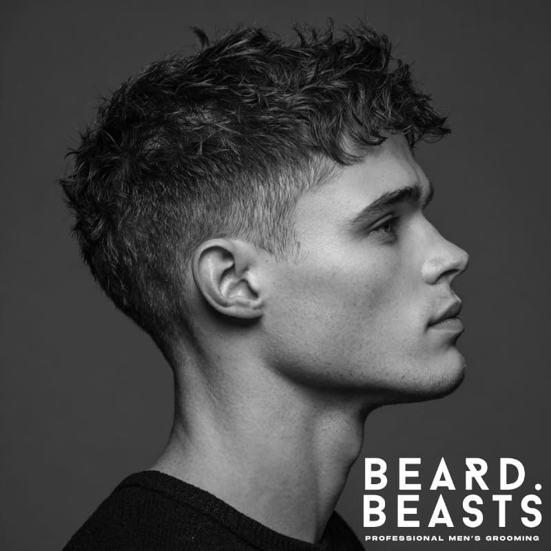 Young man with a classic textured crop haircut, showcasing a clean, defined style with short layers and a smooth fade.