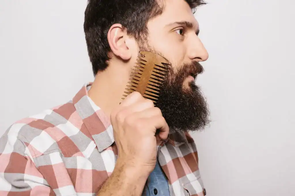 Man combing a wiry beard as part of a simple daily grooming routine