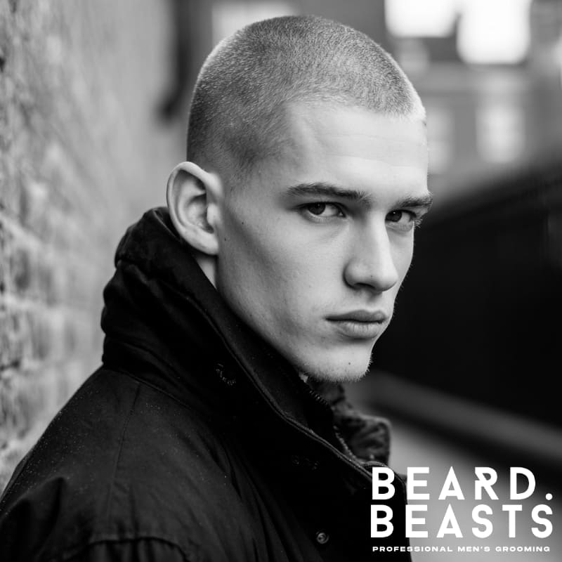 A clean buzz cut hairstyle for men with a diamond face shape, featuring evenly trimmed short hair all around. This minimalistic haircut enhances the sharp features of a diamond-shaped face, offering a bold, strong look with a low-maintenance, clean finish.