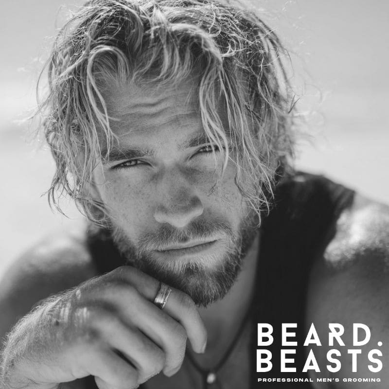 Close-up of a male model with sun-kissed blonde beachy waves, showcasing natural, textured surfer hair, wet from the ocean.