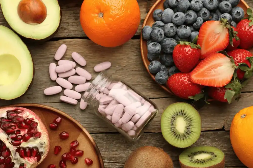 Fresh fruits alongside vitamin supplements illustrating fruit versus supplements for beard growth support
