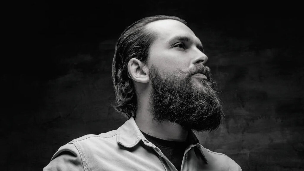 Man with a full beard showing defined cheek line, highlighting the importance of not ignoring cheek line trimming