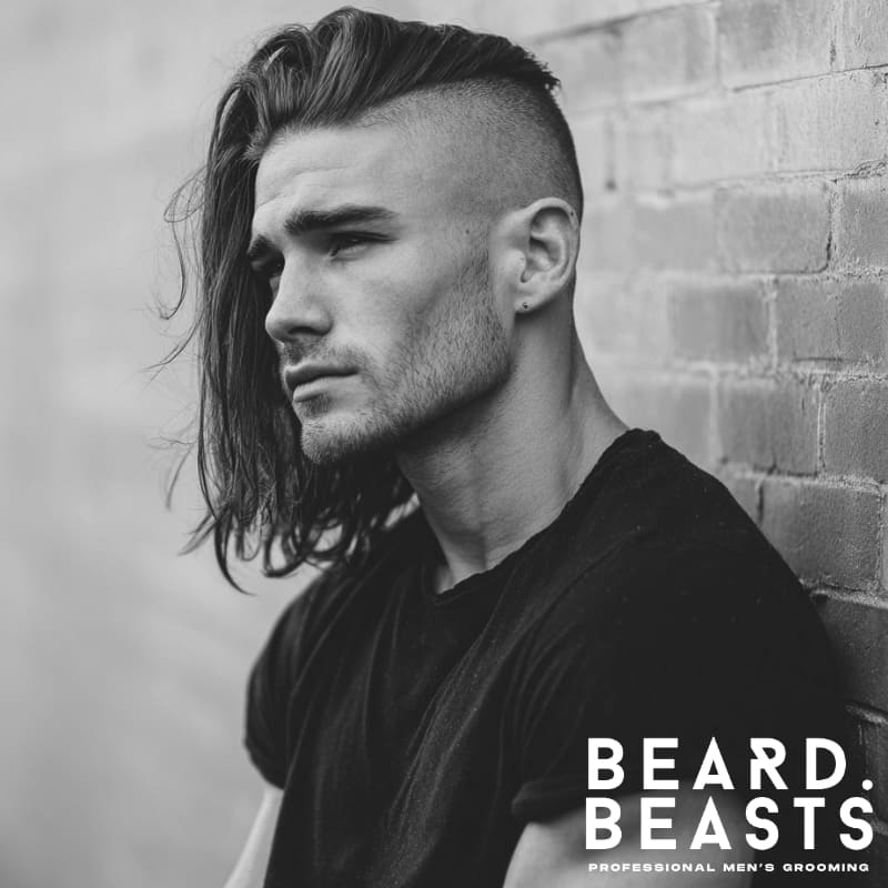 A bold hairstyle with long, thick hair on top styled to one side, contrasted by a clean undercut on the sides. This modern look combines volume and texture, making it a perfect choice for men who want a stylish and edgy appearance. A great option for those seeking men’s hairstyles for long hair with a contemporary twist.