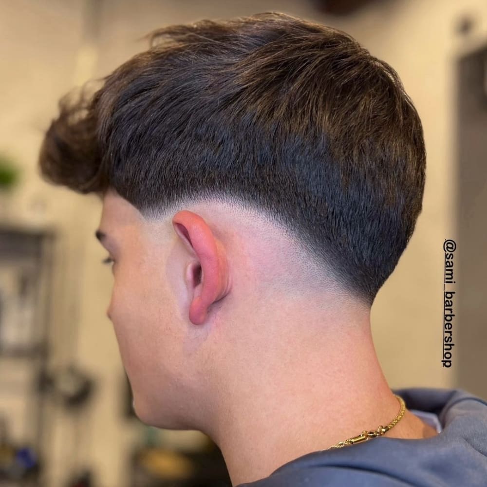 Man with a low skin fade haircut, featuring a sharp fade that transitions smoothly from very short hair to skin, creating a modern and edgy look.