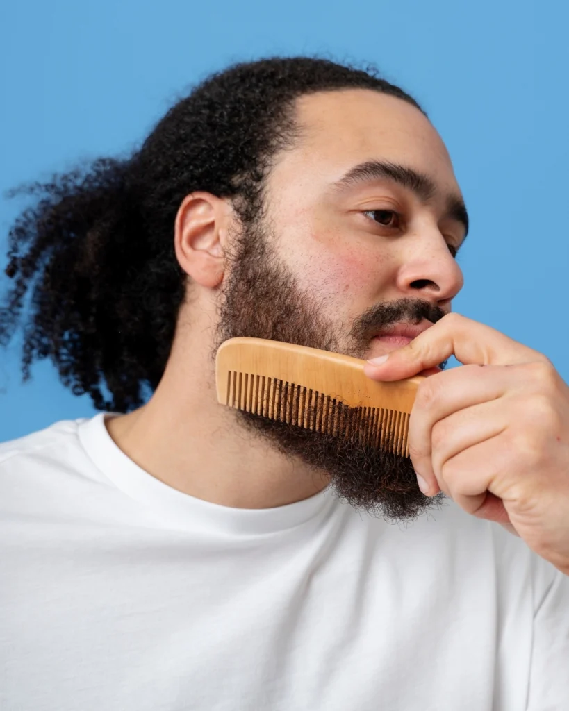 Man combing his coarse beard with a wooden comb