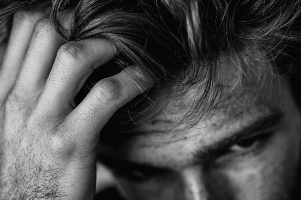 Man running his fingers through textured hair styled with sea salt spray.