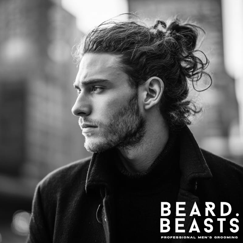 A stylish man with naturally curly hair, sporting a messy man bun, showcasing a trendy and effortless look. Perfect for those seeking inspiration for modern, versatile men’s hairstyles for long hair.