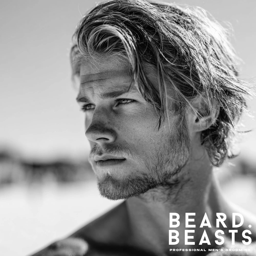 Man with medium length straight surfer hair styled in a relaxed beach look