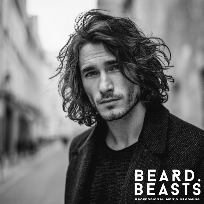 A stylish shoulder-length men’s hairstyle with soft waves, offering natural texture and movement. Perfect for men with wavy or textured hair, this look combines relaxed sophistication with volume and effortless style.
