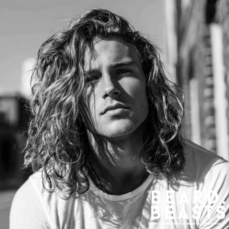 A relaxed, natural look with long, textured, wavy hair. Perfect for guys who want a laid-back, beach-inspired vibe with minimal styling. Ideal for wavy hair types, this carefree style combines effortless layers and movement, making it a top choice for stylish men’s hairstyles for long hair.