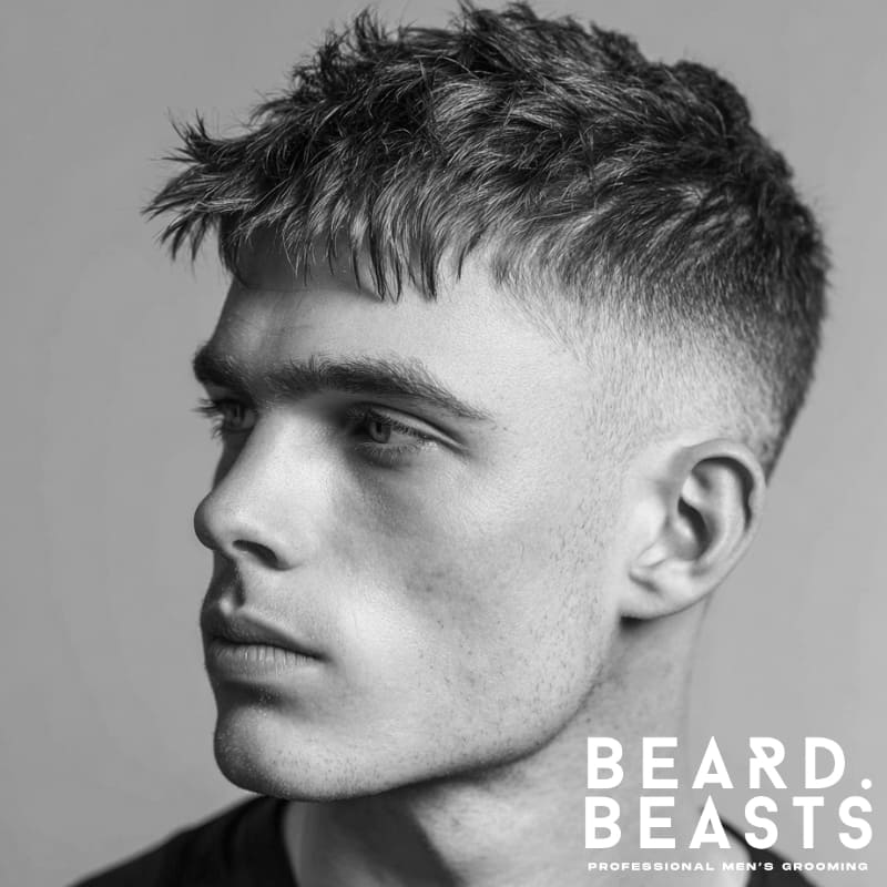 Young man with a textured crop and fade, featuring a choppy top and clean fade on the sides for a sharp, modern look.