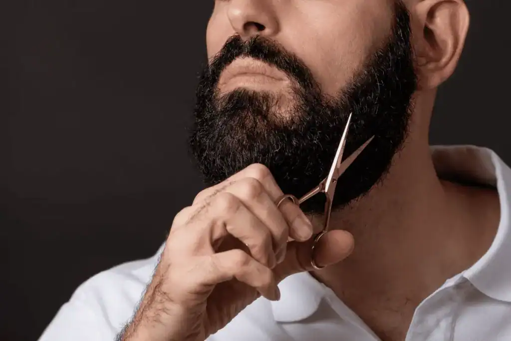 Man trimming a wiry beard too frequently, creating blunt ends and stiffness