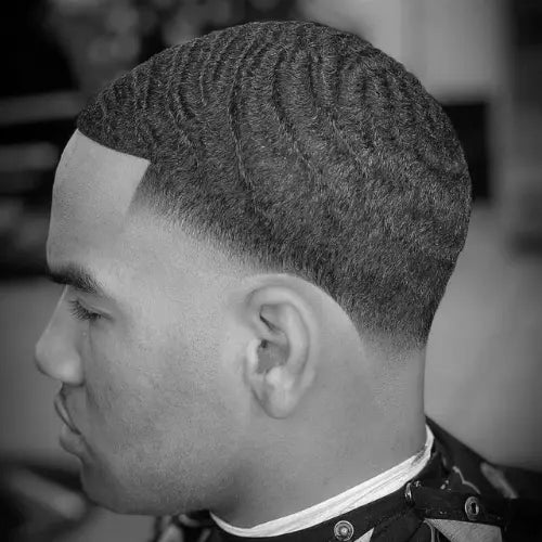 A crisp and stylish waves fade haircut for Black men, featuring deep, well-defined 360 waves paired with a smooth, low fade that seamlessly blends into the skin. The sharp lineup enhances the clean and polished look, making this fade haircut a top choice for men seeking a classic yet modern style.