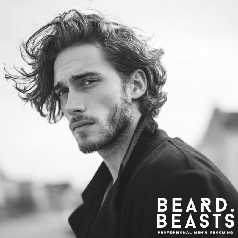 "Handsome male model sporting a stylish men's flow haircut with relaxed, tousled waves and natural volume. Ideal inspiration for modern men's flow hairstyles with wavy hair.