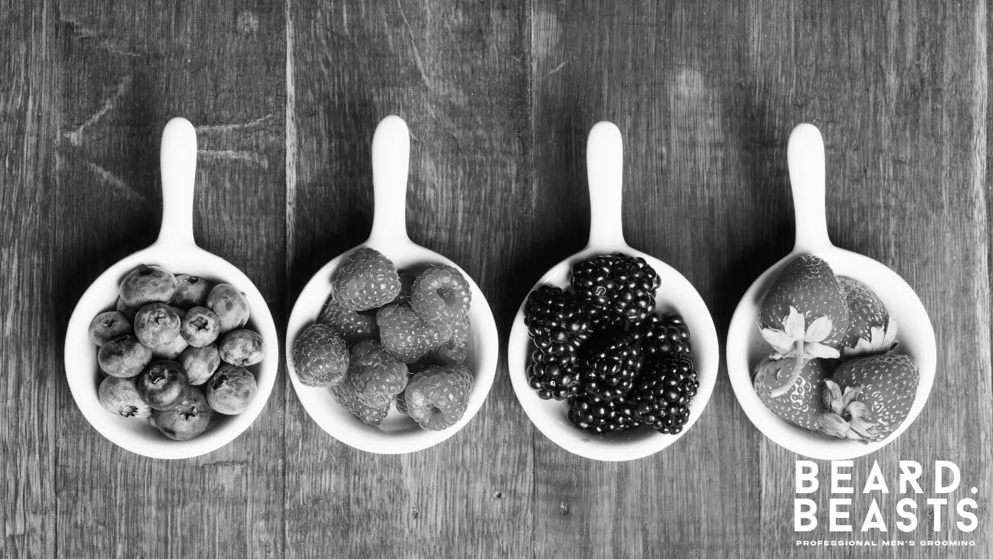 Bowls of fresh strawberries, raspberries, blackberries, and red currants rich in antioxidants and vitamin C that help protect beard follicles and support thicker, healthier beard growth.