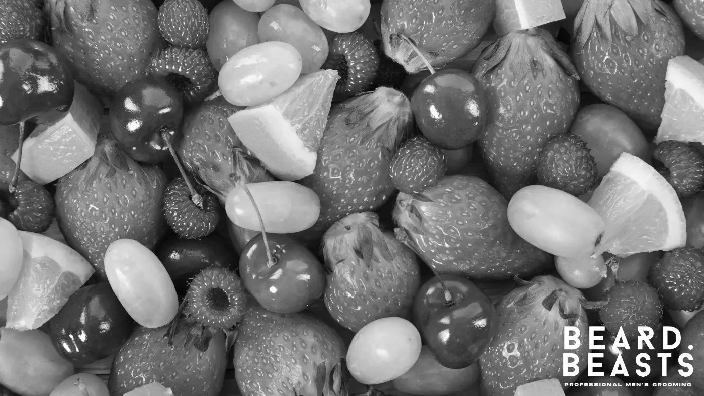 A collection of vitamin-rich fruits beneficial for beard growth, including grapes, oranges, and kiwi.