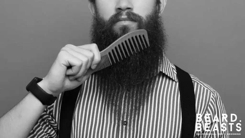 Man grooming his coarse beard with a wide-tooth comb to prevent breakage and maintain shape.