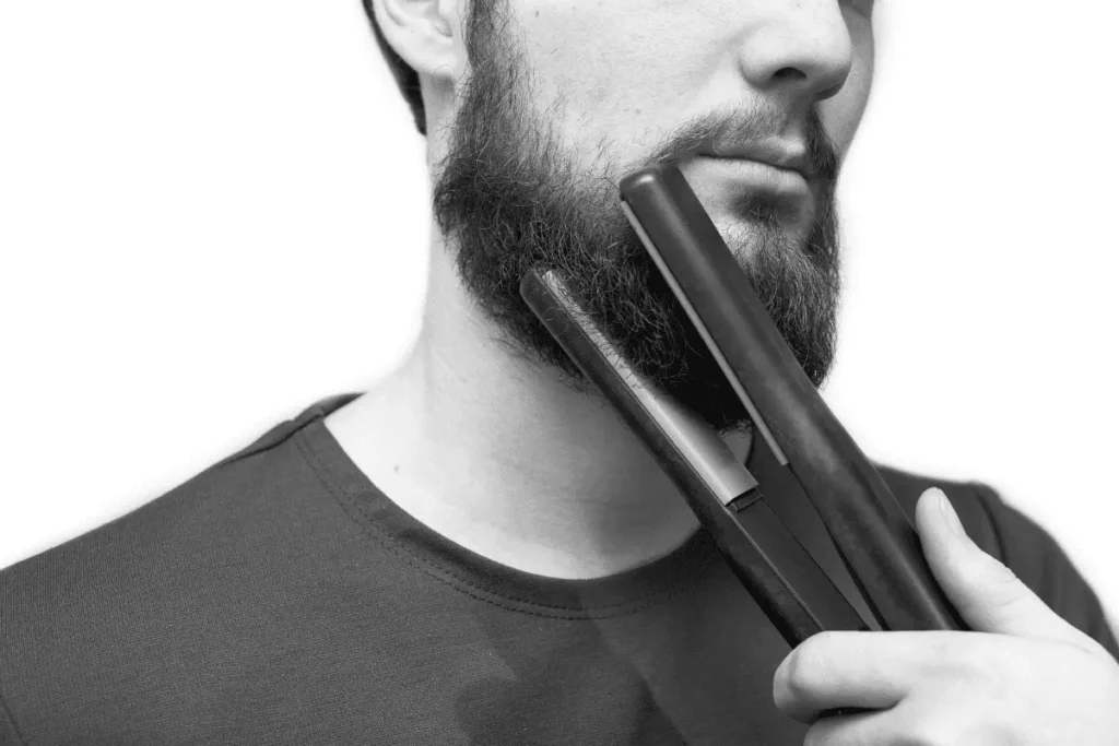 Do beard straighteners work on short beards? Example of a man using a flat iron on short beard hair.